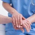 nurse holding the hand of a patient