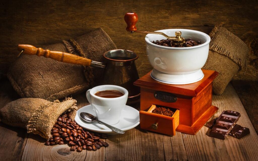 coffee grinder, coffee beans and a nice cup of coffee