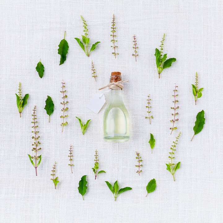 natural oil bottle surrounded by leaves alternative to parabens
